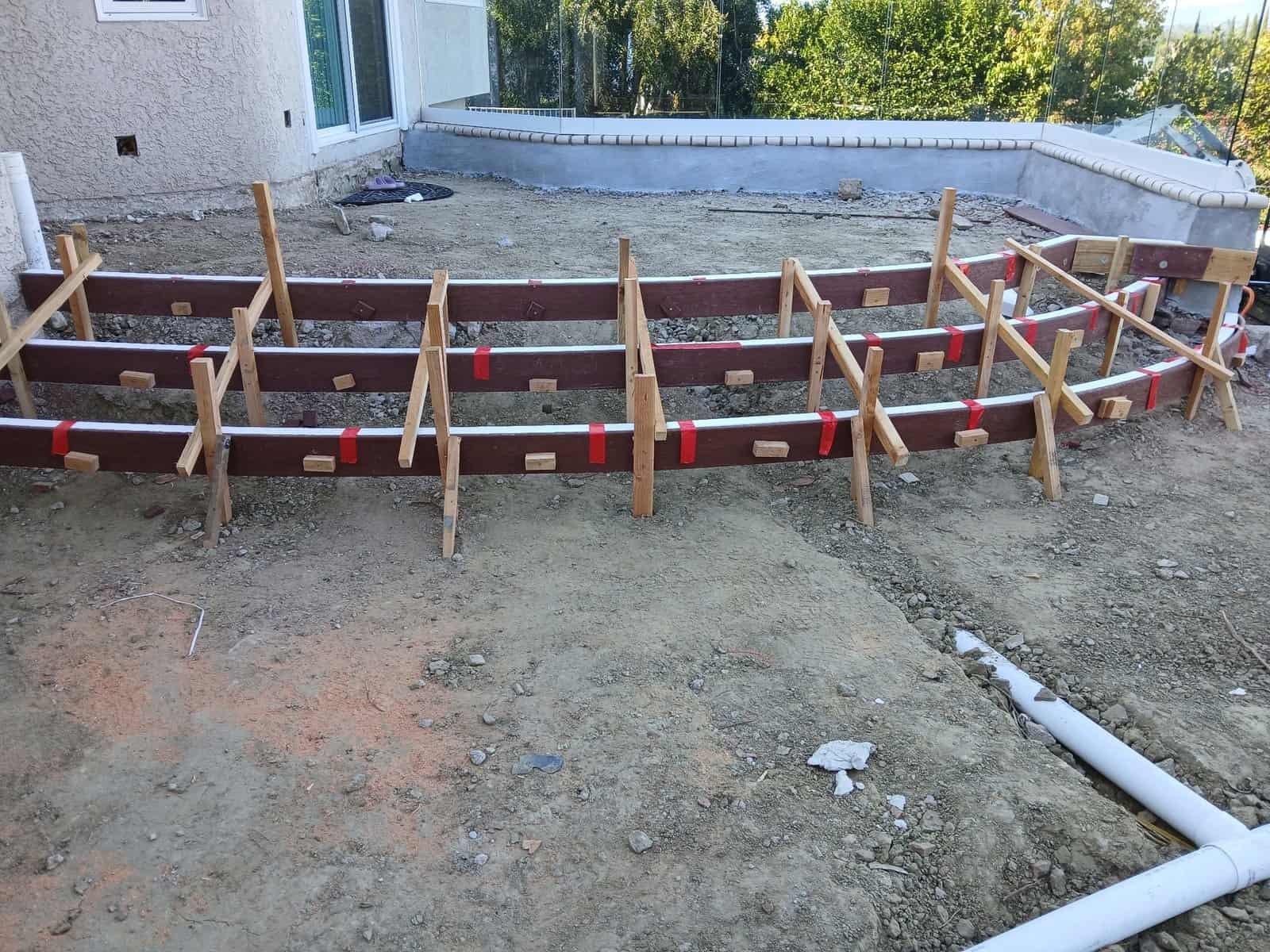 Concrete foundation formwork with wooden and metal supports for residential building.