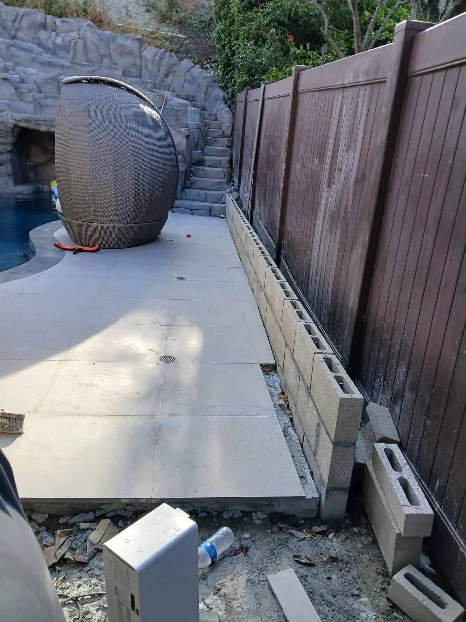 Concrete patio with retaining wall and outdoor furniture.