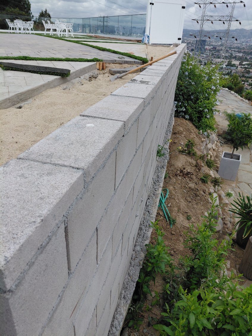 Concrete retaining wall built with concrete blocks for landscaping and support.